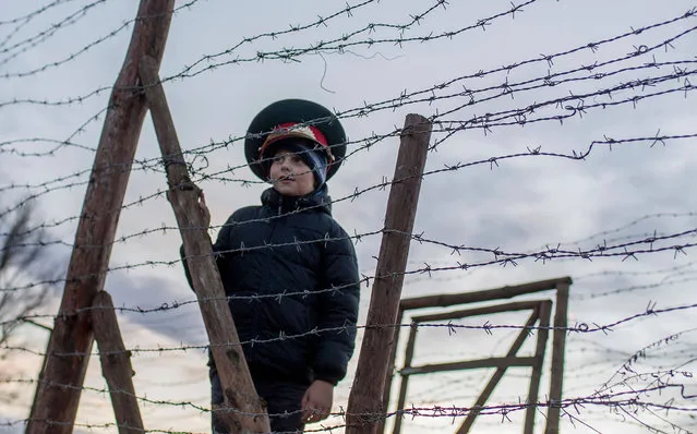 Matus, a seven- year- old Slovak boy, wears a Soviet military hat as he stands by remains of the border fences from the former “Iron curtain” between Slovakia and Austria on November 20, 2016 near Bratislava, Slovakia. The bridge was symbolically closed for 3 days to remeber victims who lost their lives trying to escape the communist regime. Slovaks and Czechs commemorated on 17 of November 26 th anniversary of the Velvet revolution. (Photo by Joe Klamar/AFP Photo)