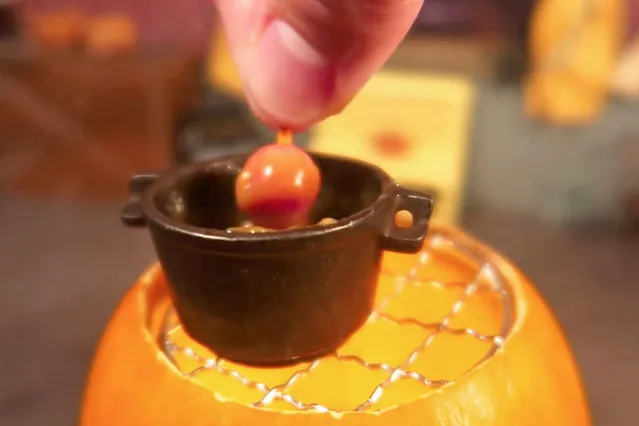 Jay dips the apples in caramel. (Photo by Jay Baron/Caters News)