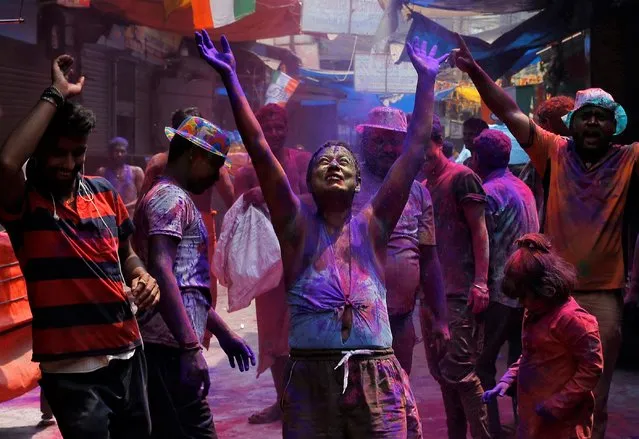 People dance as they throw coloured powder at each other during Holi celebrations, amidst the spread of the coronavirus disease (COVID-19), in Kolkata, India, March 29, 2021. (Photo by Rupak De Chowdhuri/Reuters)