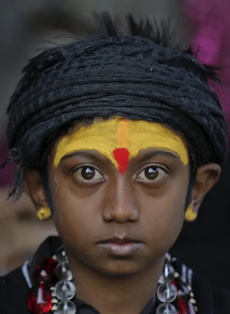 A young Hindu pilgrim on his way to the annual holy dip at Gangasagar, looks on as he rests at a transit camp in Kolkata, India, Wednesday, January 6, 2016. Thousands of Hindu pilgrims are expected to take the annual holy dip at Gangasagar, where the Ganges River reaches the Bay of Bengal, on the auspicious Makar Sankranti festival day that falls on Jan.14. (Photo by Bikas Das/AP Photo)