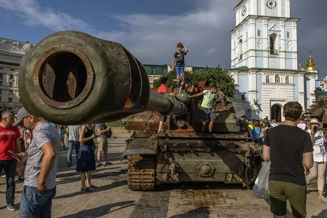 Boys climb on a Russian tank which was destroyed in fights with the Ukrainian army,  displayed at Mykhailivskyi Square, in Kyiv, Ukraine, 12 June 2022. On 24 February Russian troops entered Ukrainian territory starting a conflict that has provoked destruction and a humanitarian crisis. (Photo by Roman Pilipey/EPA/EFE)