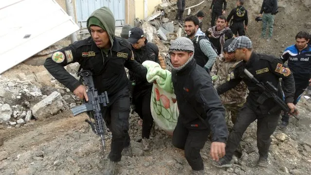 Iraqi security forces and pro-government Sunni tribal fighters evacuate a badly injured man in Ramadi city, Iraq January 4, 2016. (Photo by Reuters/Stringer)