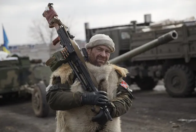 A Russia-backed rebel holds a heavy machine-gun in Debaltseve, Ukraine, Friday, Feb. 20, 2015. After weeks of relentless fighting, the embattled Ukrainian rail hub of Debaltseve fell Wednesday to Russia-backed separatists, who hoisted a flag in triumph over the town. The Ukrainian president confirmed that he had ordered troops to pull out and the rebels reported taking hundreds of soldiers captive.(AP Photo/Vadim Ghirda)