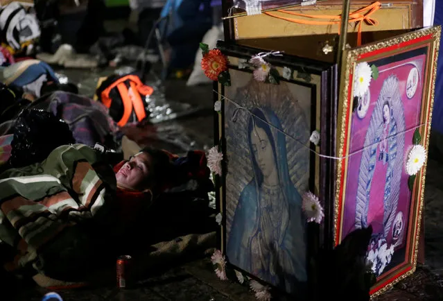 A pilgrim rests beside images of the Virgin of Guadalupe at an improvised camp site at the Basilica of Guadalupe during the annual pilgrimage in honor of the Virgin of Guadalupe, patron saint of Mexican Catholics, in Mexico City, Mexico December 11, 2016. REUTERS/Henry Romero
