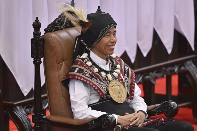 Indonesian President Joko Widodo, wearing traditional attire from Tanimbar Islands of Maluku province, takes his seat before delivering his State of the Nation Address ahead of the country's Independence Day, at the parliament building in Jakarta, Indonesia, Wednesday, August 16, 2023. (Photo by Adek Berry/Pool Photo via AP Photo)