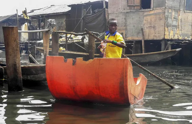 A Nigerian pupil rows to school using a makeshift canoe out of half a plastic barrel as he makes his way to a floating school in Makoko, Lagos, Nigeria 09 March 2015. The school built for children of Makoko riverine  community who live in homes over the water was supported by the United Nations Development Program (UNDP).  EPA/STR