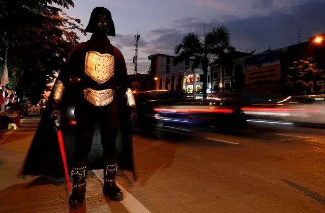 A person in costume stands at the side of a road during a gathering of the supporters of anti-government protest leaders arrested and charged with lese majeste, waiting for their release in Bangkok, Thailand on May 11, 2021. (Photo by Jorge Silva/Reuters)