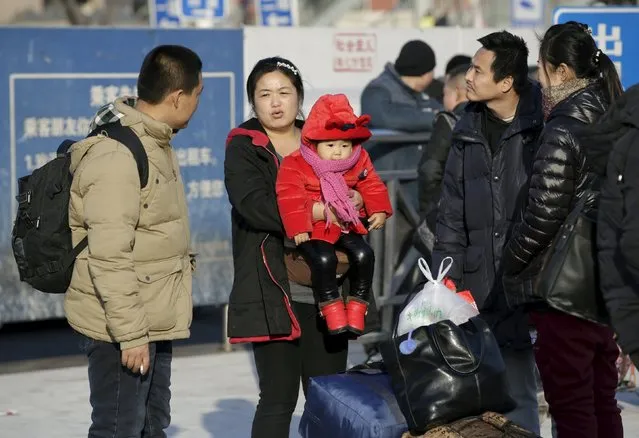 Pan Siqi, 22 months old, is carried by her mother as they wait for the train to their hometown Dandong of Liaoning province at Beijing Railway Station, in Beijing, China, January 25, 2016. (Photo by Jason Lee/Reuters)