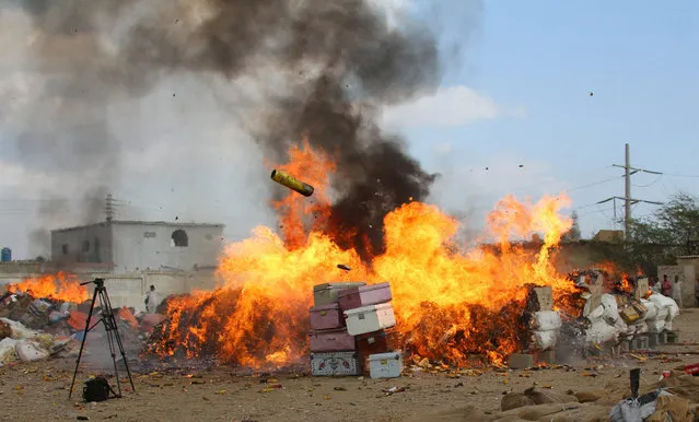 Drugs which were confiscated during different operations throughout the year are burnt to mark the International Customs Day, in Karachi, Pakistan, 26 January 2016. Pakistani officials on International Customs Day set ablaze 16Kg Heroine, 22400 Liquor bottles and 54611 beer cans, fake cigarettes and expired medicines. (Photo by Rehan Khan/EPA)