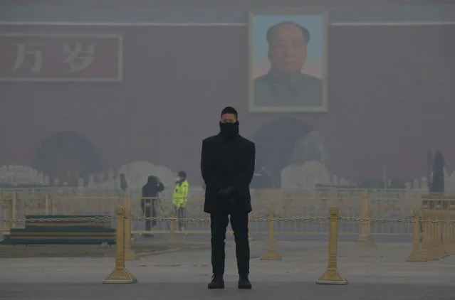 A member of the security personnel wearing a mask stands guard in the smog at Tiananmen Square after a red alert was issued for heavy air pollution in Beijing, China, December 20, 2016. (Photo by Jason Lee/Reuters)