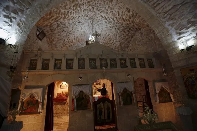 A man is seen inside St. George Church, also know as the Church of the Ten Lepers, in the West Bank town of Burqin near Jenin March 22, 2015. Residents of Burqin, where one of the world's oldest church is located, aspire to put their town on the world tourism map by implementing  several projects aimed at developing the infrastructure and historical buildings. (Photo by Mohamad Torokman/Reuters)