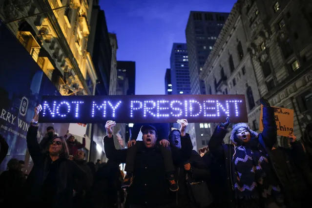 Demonstrators protest against US President-elect Donald Trump in front of Trump Tower on November 12, 2016 in New York. Americans spilled into the streets Saturday for a new day of protests against Donald Trump, even as the president-elect appeared to back away from the fiery rhetoric that propelled him to the White House. (Photo by Kena Betancur/AFP Photo)