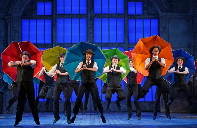 Cast members, including (left to right) Adam Cooper (2nd left, yellow umbrella), Charlotte Gooch (centre, blue umbrella) and Kevin Clifton (4th right, green umbrella) at the rehearsals for Singin' in the Rain, before it re-opens later this week at Sadlers Wells Theatre in London on Tuesday, August 3, 2021. (Photo by Yui Mok/PA Images via Getty Images)