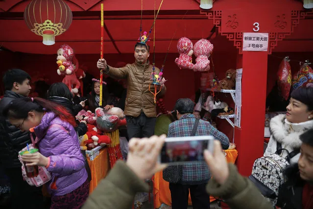A vendor offers monkeys and other toys for sale as the Chinese Lunar New Year, which welcomes the Year of the Monkey, is celebrated at the temple fair at Ditan Park (the Temple of Earth), in Beijing, China February 11, 2016. (Photo by Damir Sagolj/Reuters)