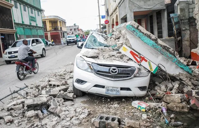 A car damaged is pictured under debris after a 7.2 magnitude earthquake in Les Cayes, Haiti on August 15, 2021. (Photo by Ralph Tedy Erol/Reuters)