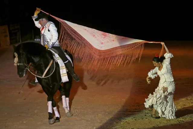 An Andalusian man and woman in traditional Sevillana garb perform with a horse during the Sacab Andalusian Horse Show in Coin, southern Spain, April 12, 2015. (Photo by Jon Nazca/Reuters)