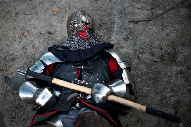 A man in full medieval armor lies on the ground after taking part in a combat at Central Park in New York, U.S., August 14, 2021. (Photo by Eduardo Munoz/Reuters)