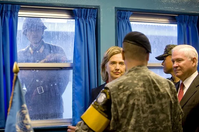 A North Korean soldier (L) looks in through the window of the T2 building as U.S. Secretary of State Hillary Clinton and U.S. Defense Secretary Robert Gates (R) tour the Demilitarized Zone (DMZ) in Panmunjom, South Korea, in this July 21, 2010 file photo. (Photo by Cherie Cullen/Reuters)