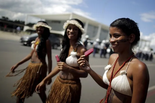 Brazilian Indian women are seen sucking ice cream in protest during a National Indigenous Mobilization in front of Planalto Palace in Brasilia April 15, 2015. (Photo by Ueslei Marcelino/Reuters)