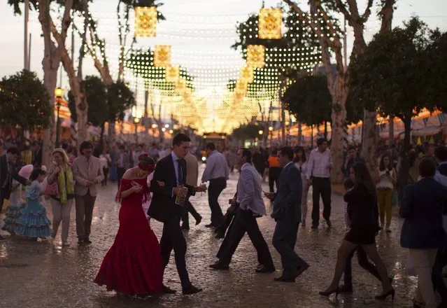People walk at sunset during the traditional Feria de Abril (April fair) in the Andalusian capital of Seville, southern Spain, April 22, 2015. (Photo by Marcelo del Pozo/Reuters)