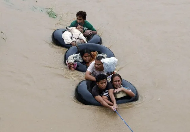 Flood victims are pulled on inflatable tire tubes as they are evacuated from heavy flooding brought by tropical depression “Agaton”, in Butuan, in the southern Philippine island of Mindanao January 20, 2014. Floods and landslides caused by tropical depression “Agaton”  have killed 40 people and more than 500,000 people are displaced in Mindanao, the National Disaster Risk Reduction and Management Council reported on Sunday. (Photo by Erik De Castro/Reuters)