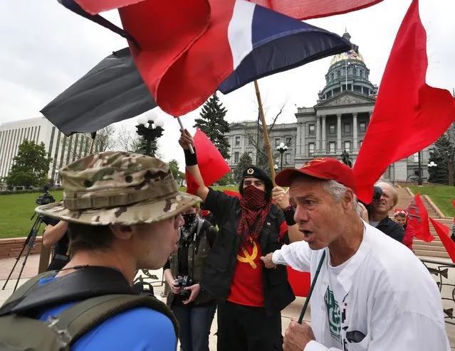 David Pittenger, left, argues with participants in a May Day rally in front of the state Capitol in Denver, Friday, May 1, 2015. (Photo by Brennan Linsley/AP Photo)