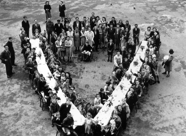 Children sit down to a victory party at a V-shaped table, given by residents at Kentwell Close, Brockley in south London. (Photo by Reg Speller/Getty Images)