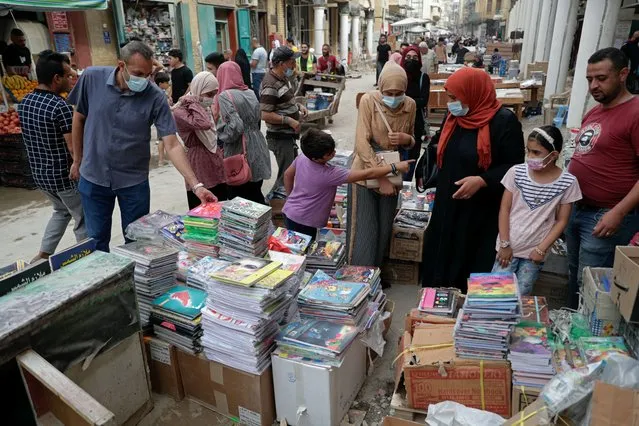 People shop for school supplies in preparation for the new school year, in Baghdad, Iraq, Sunday, October 31, 2021. (Photo by Khalid Mohammed/AP Photo)