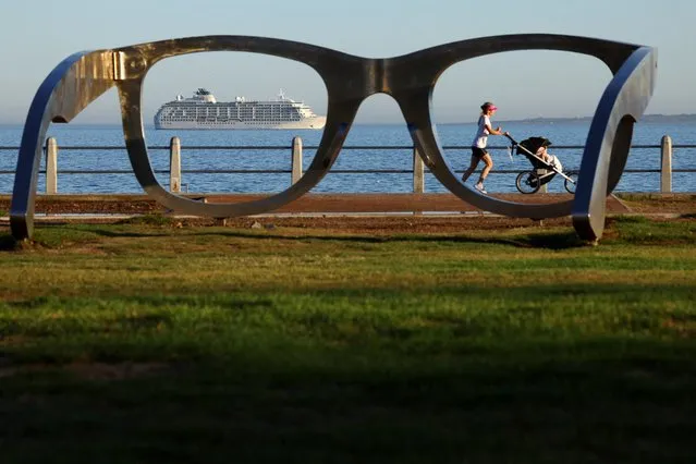 A lady runs with a pram along the Sea Point Promenade as The World, an exclusive private residential ship during its 2024 journey to six continents, arrives in Cape Town,  South Africa, on February 28, 2024. (Photo by Esa Alexander/Reuters)