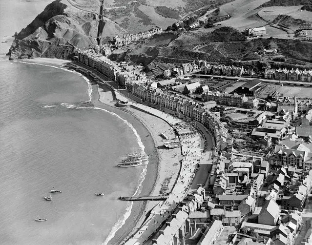 General view of Aberystwyth showing seafront and town in summer, The dignified seafront of Aberystwyth is captured here in the summer of 1932, with pleasure boats moored on the beach ready to take holidaymakers on trips around Cardigan Bay