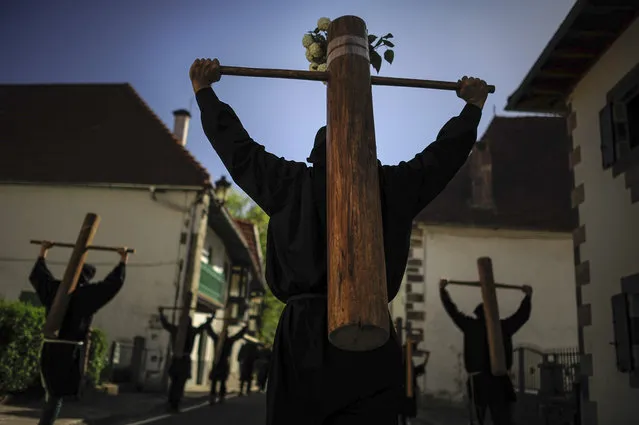 Masked penitents holds their crosses during spring “Romeria Cruceros de Arce”, in Roncesvalles, northern Spain, Sunday, May 10, 2015. (Photo by Alvaro Barrientos/AP Photo)