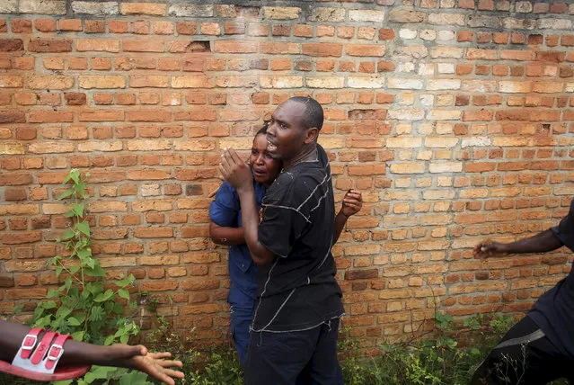 A man tries to protect a female police officer accused of shooting a protester from other protesters in the Buterere neighborhood of Bujumbura, Burundi, May 12, 2015. (Photo by Goran Tomasevic/Reuters)