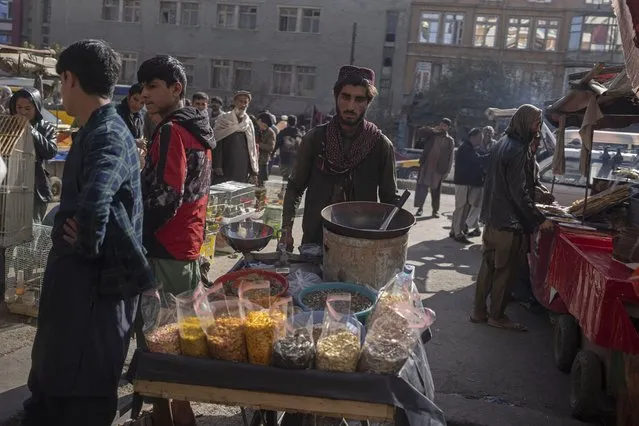 A street vendor pushes his cart in a market in Kabul, Afghanistan, Tuesday, November 16, 2021. (Photo by Petros Giannakouris/AP Photo)