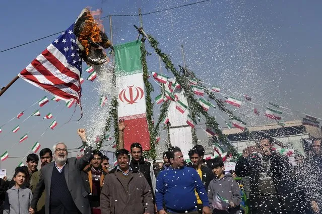 Demonstrators burn a U.S. flag during their annual rally commemorating Iran's 1979 Islamic Revolution in Tehran, Iran, Sunday, February 11, 2024. Iran marked Sunday the 45th anniversary of the 1979 Islamic Revolution amid tensions gripping the wider Middle East over Israel's continued war on Hamas in the Gaza Strip. (Photo by Vahid Salemi/AP Photo)