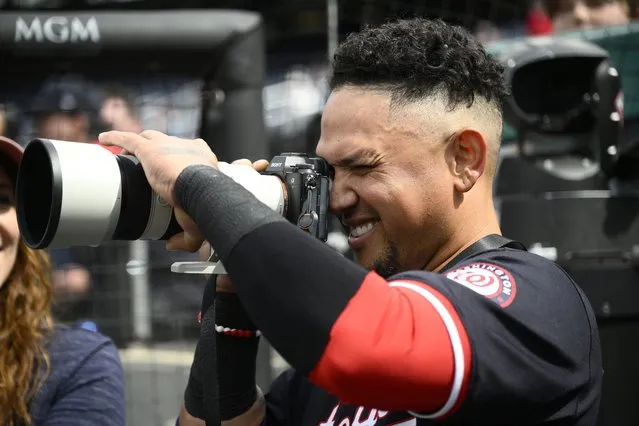 Washington Nationals' Ildemaro Vargas uses a photographers camera during the seventh inning of an exhibition baseball game against the Washington Nationals Futures, Tuesday, March 26, 2024, in Washington. (Photo by Nick Wass/AP Photo)