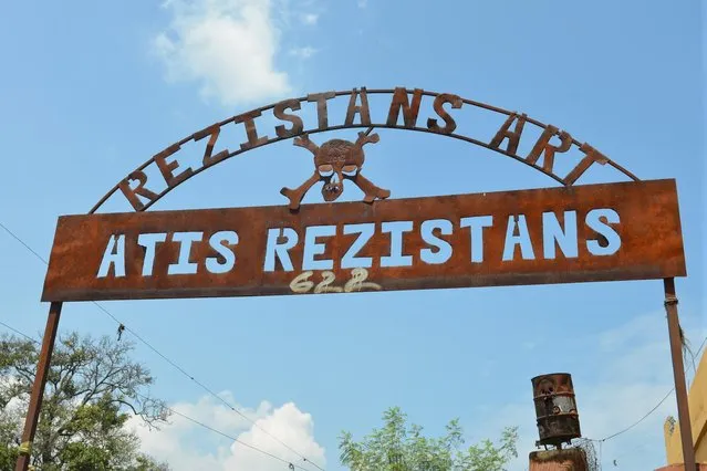 In this April 6, 2016 photo the metal archway of Atis Rezistans stands outside an open-air museum and art workshop off a trash-strewn street called Grand Rue in Port-au-Prince, Haiti. The site is in the yard of a founding member of a loose collective of Haitian artists who have become celebrated in the international art world by creating sculptures out of scrapped car parts, old wood, discarded toys and even human skulls found scattered outside crumbling mausoleums. (Photo by David McFadden/AP Photo)