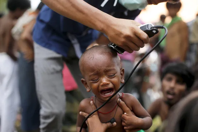 A Rohingya migrant child, who recently arrived in Indonesia by boat, cries as a volunteer cuts his hair inside a temporary compound for refugees in Aceh Timur regency, Indonesia's Aceh Province, May 22, 2015. (Photo by Reuters/Stringer)