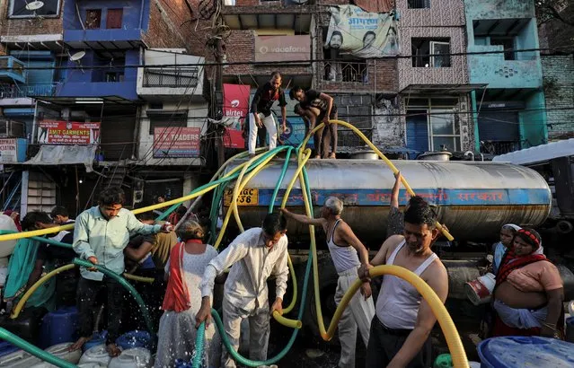 Residents fill their containers with drinking water from a municipal tanker in New Delhi, June 14, 2019. (Photo by Anushree Fadnavis/Reuters)