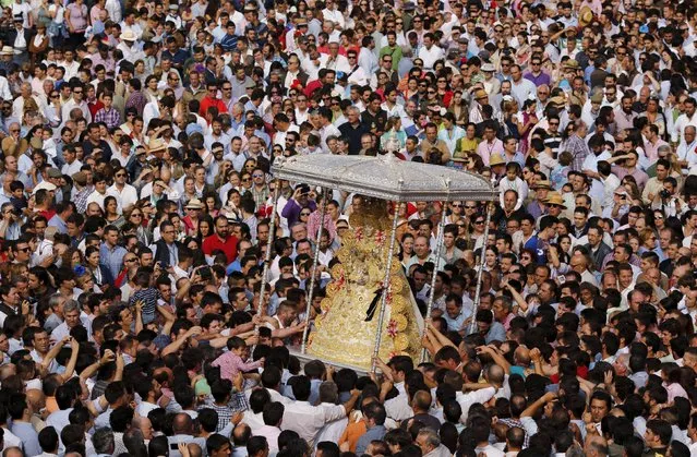 Pilgrims crowd around the Virgin of El Rocio during a procession around the shrine of El Rocio in Almonte, southern Spain, May 25, 2015. (Photo by Marcelo del Pozo/Reuters)