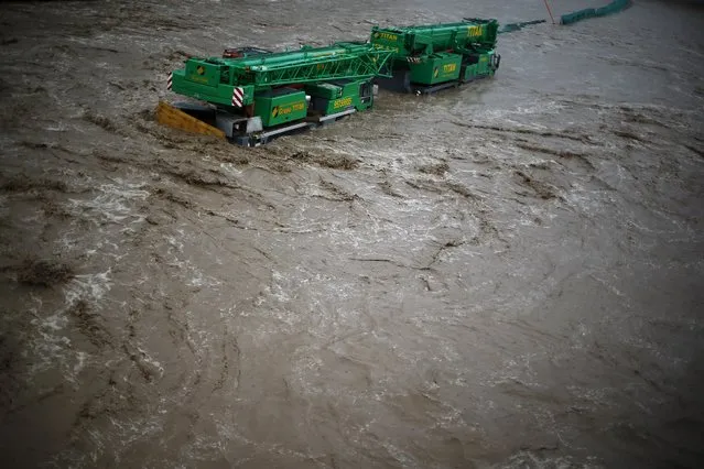 Cranes are seen on a flooded street in Santiago, April 17, 2016. (Photo by Ivan Alvarado/Reuters)