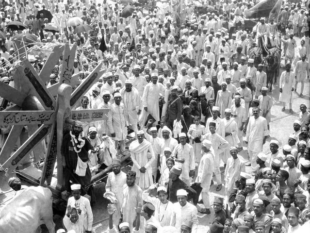 Original caption, from India, in August of 1922: “A Gandhi procession reminds one of a carnival celebration. Volunteers in the non-cooperative movement dress in their home-woven costumes and shout 'Swaraj' (home-rule). A huge spinning wheel leads the procession as an emblem of Gandhiism”. (Photo by Bettmann Archive)