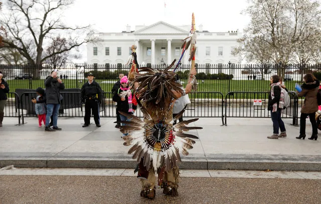 Little Thunder, a traditional dancer and indigenous activist from the Lakota tribe, dances as he demonstrates in front of the White House during a protest march and rally in opposition to the Dakota Access and Keystone XL pipelines in Washington, U.S., March 10, 2017. (Photo by Kevin Lamarque/Reuters)