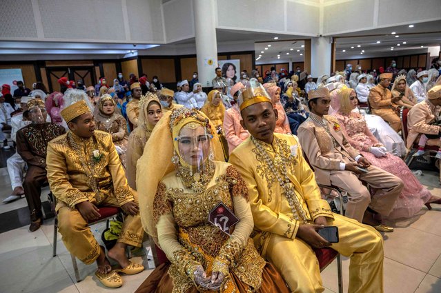 People take part in a mass wedding ceremony that was organized by local government social services in Surabaya on December 23, 2021. (Photo by Juni Kriswanto/AFP Photo)