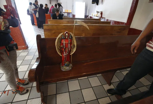 In this February 19, 2017 photo, a statue of the Death Saint or “La Santa Muerte”, sits on a pew at Mercy Church, located on the edge of Mexico City's Tepito neighborhood. Images of La Santa Muerte range from mass-produced articles sold in shops throughout Mexico and the U.S., to handcrafted effigies. (Photo by Marco Ugarte/AP Photo)