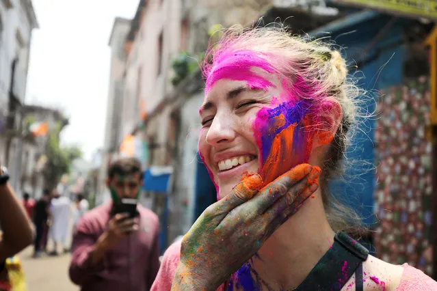 Tourists and locals apply colour dust to each other as they celebrate Holi festival in Kolkata, Eastern India, 28 March 2021. (Photo by Piyal Adhikary/EPA/EFE)