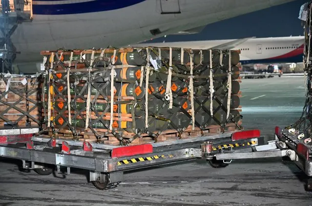 A picture taken on January 25, 2022 shows pallets of ammunition, weapons and other equipment while employees unload a plane with a new US security assistance provided to Ukraine at Kyiv's airport Boryspil. The US has stepped up security assistance to Ukraine, amid fear of Russian invasion with Russia's build-up of tens of thousands of troops on Ukraine's border. (Photo by Sergei Supinsky/AFP Photo)