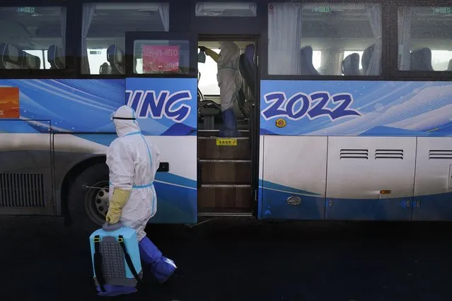 Workers in protective gear disinfect an Olympic shuttle bus ahead of the 2022 Winter Olympics, Sunday, January 30, 2022, in Zhangjiakou, China. (Photo by Jae C. Hong/AP Photo)