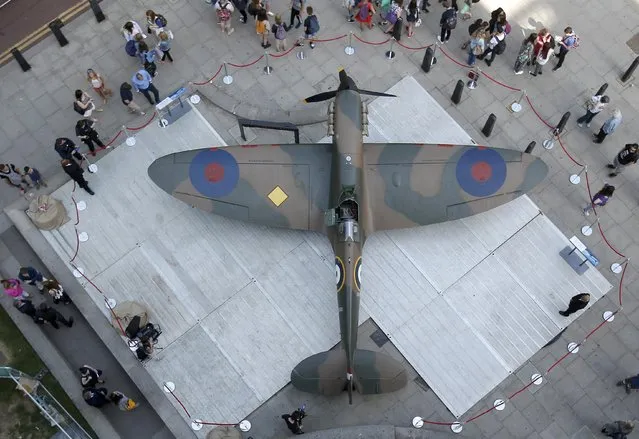 People look at a Mk.1 Spitfire, donated by American entrepreneur and philanthropist, Thomas Kaplan, on display outside the Churchill War Rooms in London, Britain July 3, 2015. The aircraft which is estimated to sell for 1.5-2.5 million pounds  ($2.3-3.9 million) will be auctioned by Christie's in London on July 9. (Photo by Peter Nicholls/Reuters)