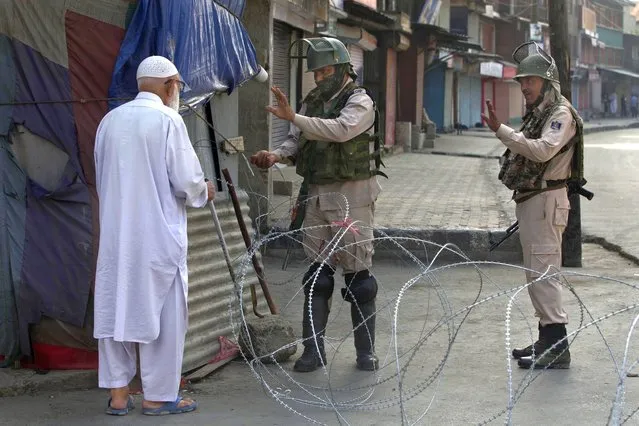An elderly Kashmiri man is stopped before being allowed to pass near a temporary checkpoint set up by Indian paramilitary soldiers during lockdown in Srinagar, Indian controlled Kashmir, Friday, August 23, 2019. The latest crackdown began just before Prime Minister Narendra Modi's Hindu nationalist-led government stripped Jammu and Kashmir of its semi-autonomy and its statehood, creating two federal territories. (Photo by Dar Yasin/AP Photo)