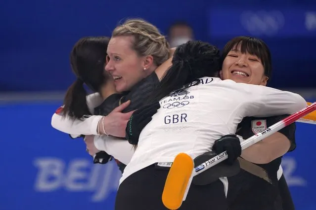Athletes hug after the women's curling final match between Japan and Britain at the Beijing Winter Olympics Sunday, February 20, 2022, in Beijing. (Photo by Brynn Anderson/AP Photo)